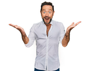 Fototapeta premium Middle age man wearing casual clothes celebrating crazy and amazed for success with arms raised and open eyes screaming excited. winner concept