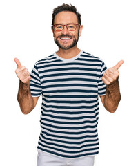 Naklejka premium Middle age man wearing casual clothes and glasses success sign doing positive gesture with hand, thumbs up smiling and happy. cheerful expression and winner gesture.