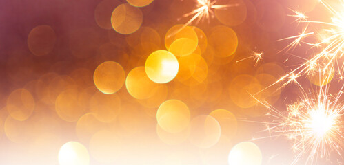 sparkling from fireworks and light bokeh. empty background for New Year's celebrations, banner design. golden color and luxury.