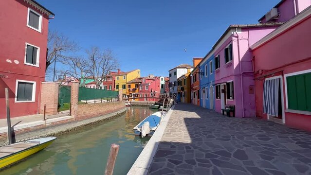 4K Gimbal Shot Unveiling Vibrant Burano Island, Venice, Italy: Colorful Houses, Tranquil Canals, Historic Ambience; Boats Drift in the Village Known for Vibrant Architecture and Cultural Heritage.
