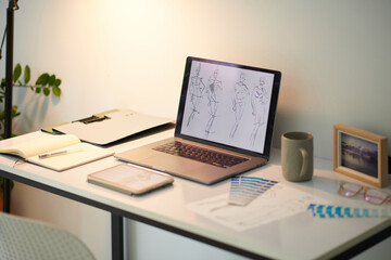 Naklejka premium Hand drawn fashion sketches on laptop screen home office concept