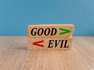 Good Evil symbol. Concept word Good and Evil on brick blocks. Beautiful wooden table, blue...