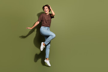 Full size photo of adorable pretty graceful woman dressed brown t-shirt pants flying hand on head isolated on khaki color background - obrazy, fototapety, plakaty