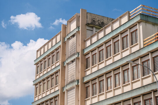 Facade of a 1960s old modernism architecture concrete building under the blue sky cloudy day in the center of Ipoh city, Perak, Malaysia.