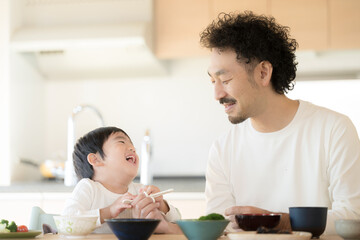 パパと一緒のご飯は美味しいね　お箸の持ち方を教える父親と子供