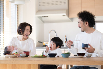 Smiling parents and children dining in a bright dining room Close-up
