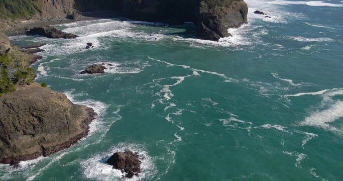 teal blue water waves crashing near rocks in brookings oregon 4k drone footage