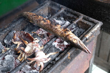 grouper, pomfret, barracuda, squid grilled on a charcoal grill. grilled sea fish. Indonesian food....