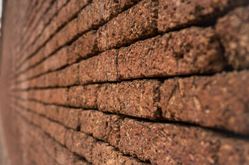 Laterite Stone wall surface red stone brick blocks  background with selective focus