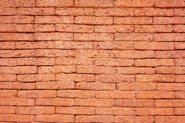 Laterite Stone wall surface red stone brick blocks  background with selective focus