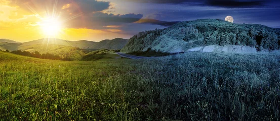 Fototapeten mountainous landscape with asphalt road winding through the valley with sun and moon on the sky. day and night time change concept. panorama of countryside scenery in morning light at summer solstice © Pellinni