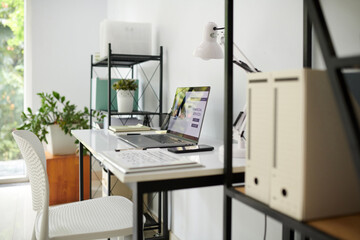 Desk of entrepreneur with opened laptop, smartphone and documents