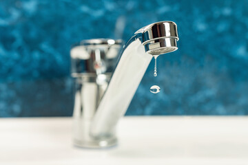 A drop of water drips from a leaky faucet