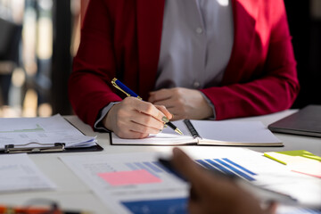 Close up Team of colleagues discussing business Accounting using calculating income-expenditure and calculator analyzing real estate investment data report Financial and tax systems concept.