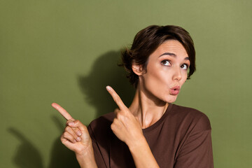Obraz premium Photo of impressed girl dressed brown t-shirt indicating staring at unbelievable sale empty space isolated on khaki color background