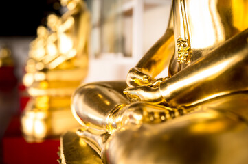 selective focus on hand of golden buddha statues buddhism thailand temple