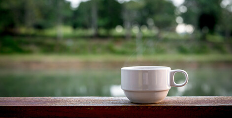 Hot coffee cup  on the wooden table and the blurred background with copy space for your text