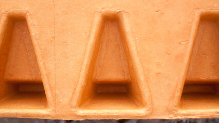 Triángulos en interior de caja de cartón naranja con relieves y huecos