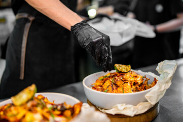 chef Cooking of crispy corn chips nachos at the restaurant kitchen