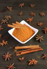 Ground cinnamon powder and sticks with star anise scattered around