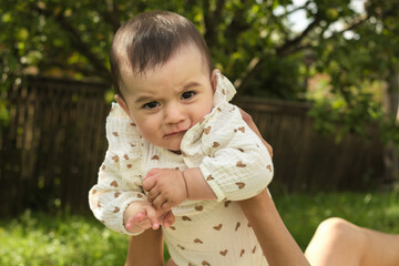 A curious baby glances over a shoulder, a moment of pure childhood wonder. Captures the innocence and exploration of early life.