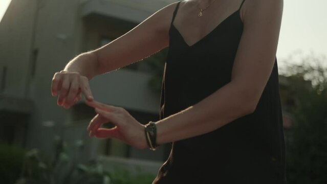 A beautiful young woman moves smoothly against the sky while practicing qigong. Solitude, harmony, meditation. The instructor of oriental practices is engaged in solitude and practices.