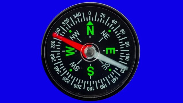 Modern magnetic compass on a blue isolated background with a red arrow defining the direction.