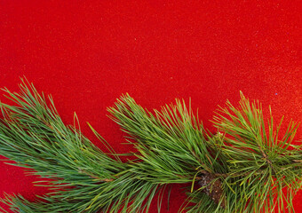 Red Christmas background with Christmas tree branch and Christmas balls and toys
