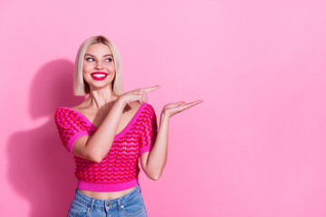 Portrait of cute positive girl toothy smile look direct finger arm hold empty space isolated on pink color background