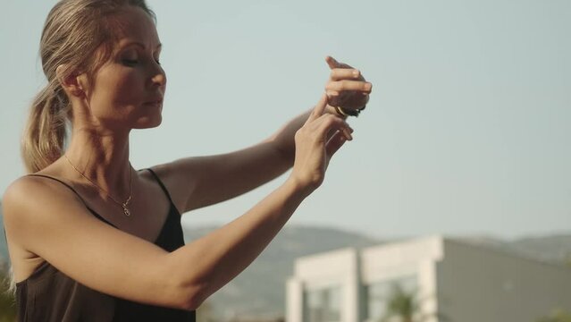 A beautiful young woman moves smoothly against the sky while practicing qigong. Solitude, harmony, meditation. The instructor of oriental practices is engaged in solitude and practices.