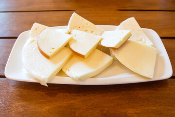 travel to Georgia - portion of various sliced Georgian brine cheeses on plate on wooden table in...