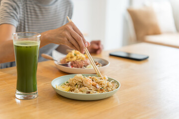 Asian Girl  eating Thai food in kitchen counter Home delivery food feeling happy 