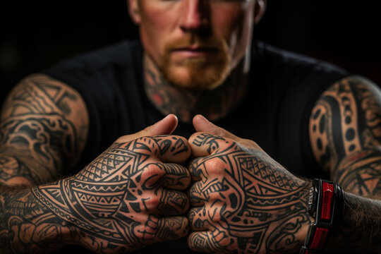 macro photograph of tattooed joined hands of a man with hard and aggressive gesture