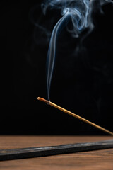 Smoke from a burning aroma stick on a black background. Incense sticks, aromatherapy and meditation.