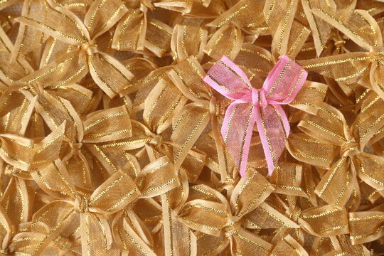 a gold bow ribbon on pink bows ribbon background