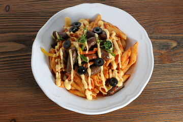 Sausage pasta and cheese with black olive served in dish isolated on table top view of arabic food