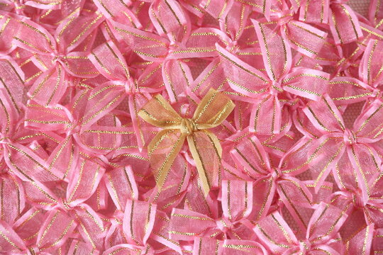 a gold bow ribbon on pink bows ribbon background