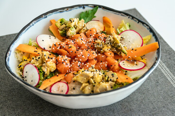 an image of a freshly prepared salmon and avocado salad on a table ready to eat