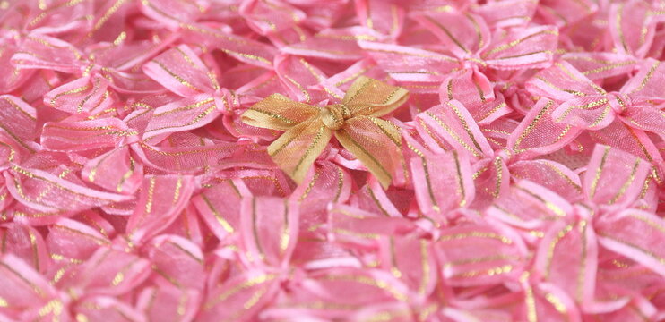 a gold bow ribbon on pink bows ribbon background