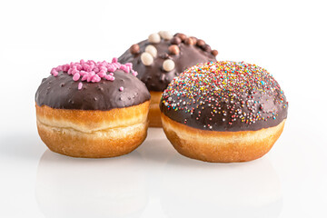 assorted chocolate glazed donuts on white glass surface close up