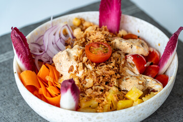a close up image of a bowl of tropical mediterranean chicken salad 