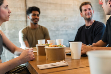 Diverse friends having lunch in cafe during party