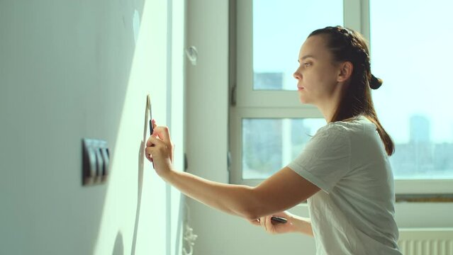 Woman applying plaster on wall. DIY house renovation, home interior design concept. Putty of joints on finishing works, slow motion