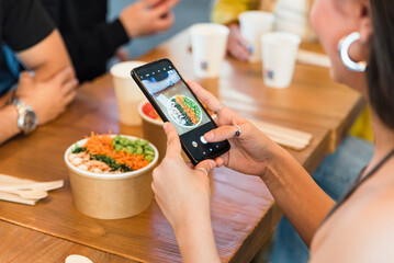 Crop woman taking photo of food in restaurant