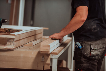 A skilled worker in the woodworking industry adeptly utilizes modern machinery to process and prepare wooden doors for the market, showcasing a seamless blend of traditional craftsmanship and cutting