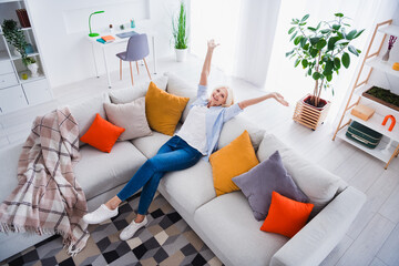 Photo portrait of charming retired woman raise hands sitting sofa done work relax stylish home...