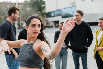 Young woman with hands in karate pose standing near diverse friends