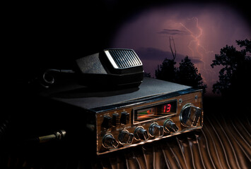 CB radio ready to transmit on channel 14 as a storm approaches with heavy lightning.