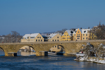 Stone bridge in Regensburg in the morning in winter with snow