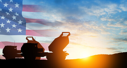 Artillery rocket system are aimed to the sky at sunset with USA flag. Multiple launch rocket system.